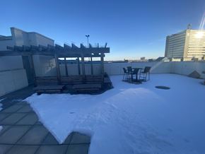 Regina condo for rent - A snow-covered rooftop with a table and chairs.