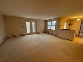 Regina condo for rent - A spacious room with a window and a door.