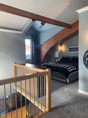 Regina condo for rent - A bedroom with a bed, a window, and a staircase.