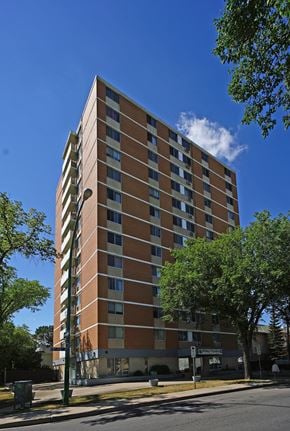 Regina apartment for rent - A tall building with a brown and beige facade stands on a street corner.