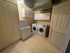 Regina condo for rent - A small laundry room with a washer and dryer.