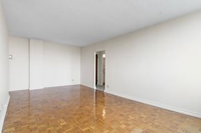Regina apartment for rent - A room with a wooden floor and a door on the right side.