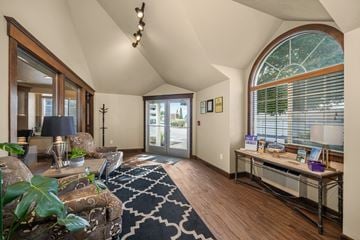 Spokane apartment for rent - a living room with a large arched window and a couch and a desk