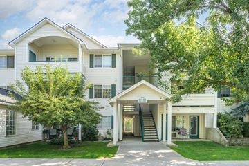 Spokane Valley apartment for rent - the outlook of a white apartment building with trees and a sidewalk