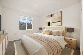 Spokane apartment for rent - A bedroom with a large bed and a window overlooking a residential area.
