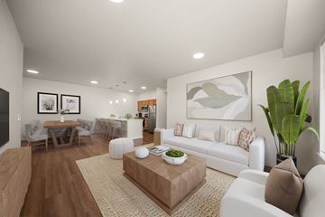 Spokane apartment for rent - A living room with a white couch, a coffee table, and a dining table with chairs.