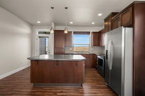 Spokane apartment for rent - A kitchen with brown cabinets, an island, and stainless steel appliances.
