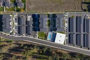 Spokane apartment for rent - A parking lot with a white building and a blue pool.