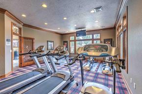 Spokane apartment for rent - a gym with treadmills and weights in the corner of a room with windows