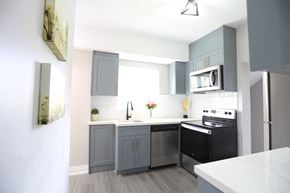 London apartment for rent - a small kitchen with black appliances and gray cabinets