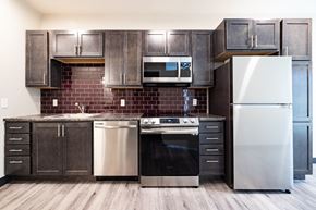 Arvada apartment for rent - A kitchen with a stainless steel refrigerator, oven, and microwave.
