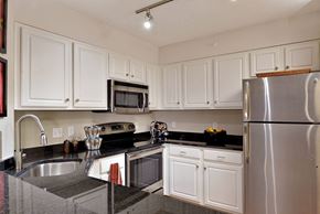 Minneapolis apartment for rent - A kitchen with white cabinets and a stainless steel refrigerator.