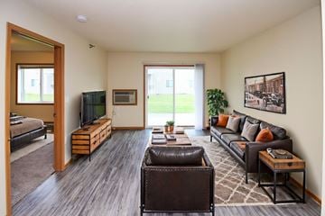 Fargo apartment for rent - A living room with a brown leather couch and a brown chair.