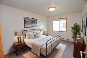 Fargo apartment for rent - A bedroom with a bed, nightstands, and a window.