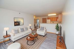 Fargo apartment for rent - A living room with a white couch, a coffee table, and a lamp.