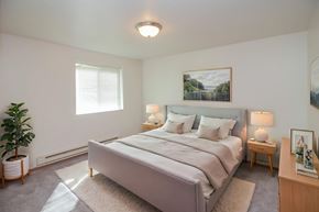 Fargo apartment for rent - A bedroom with a large bed and a potted plant.