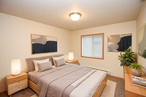 Fargo apartment for rent - A bedroom with a bed, nightstand, and window.