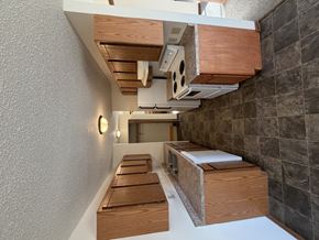 Bismarck apartment for rent - A long wooden bench is in a room with a wall of tiles.
