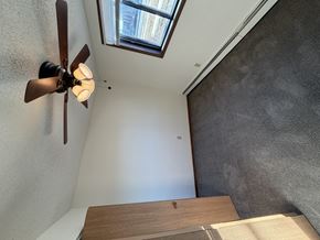 Bismarck apartment for rent - A ceiling fan with lights is mounted on a white wall above a wooden table.