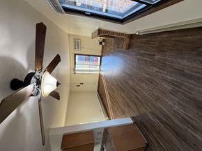 Bismarck apartment for rent - A ceiling fan with a light is mounted on a wall in a room with wooden walls and a skylight.