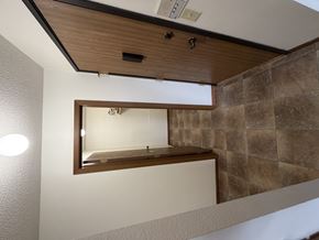 Bismarck apartment for rent - A mirror is mounted on a wall above a wooden ledge.