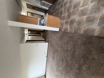 Bismarck apartment for rent - A white refrigerator is in a kitchen with a stone wall.