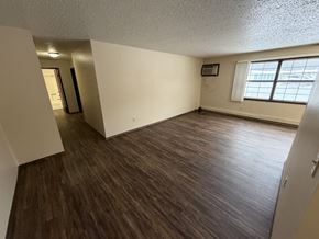 Bismarck apartment for rent - A room with wooden flooring and a window with white curtains.