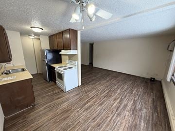 Bismarck apartment for rent - A kitchen with a white stove top oven and a black refrigerator.