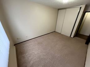 Bismarck apartment for rent - A room with a carpeted floor and a closet with white doors.