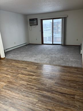 West Fargo apartment for rent - A room with wooden flooring and a sliding glass door.
