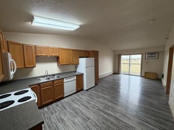 Fargo apartment for rent - A kitchen with wooden cabinets and a white refrigerator.