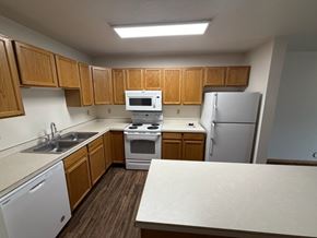 Fargo apartment for rent - A kitchen with wooden cabinets and white appliances.