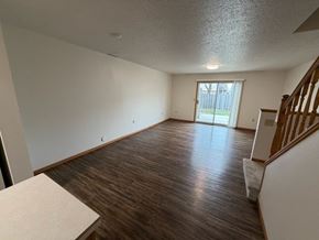 Fargo apartment for rent - A room with wooden flooring and a staircase on the right side.
