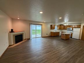 Fargo apartment for rent - A spacious living room with wood flooring and a fireplace.