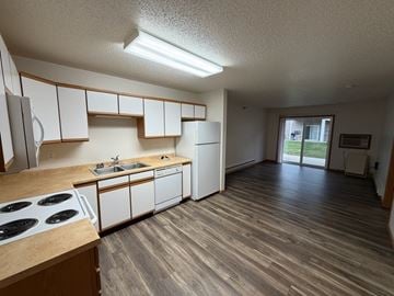 Fargo apartment for rent - A kitchen with white cabinets and a wooden floor.