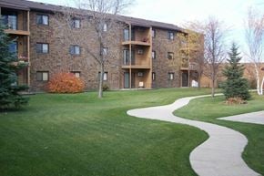 West Fargo apartment for rent - Apartment complex with a walkway in the grassy area.
