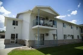 Bismarck apartment for rent - A white two-story apartment building with balconies on the second floor.