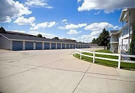 Bismarck apartment for rent - A parking lot with a white fence and a building in the background.