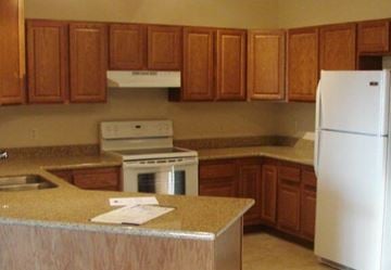 Aberdeen apartment for rent - A kitchen with a white fridge and wooden cabinets.