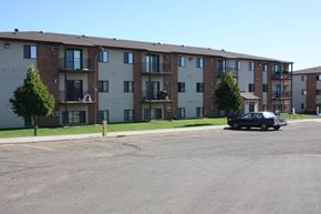 Bismarck apartment for rent - A black car is parked in a parking lot in front of apartment buildings.