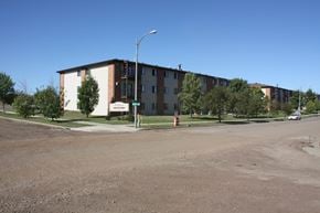 Bismarck apartment for rent - Apartment complex with a parking lot in front.