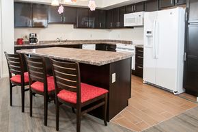 Minneapolis apartment for rent - a kitchen with a granite island and black cabinets and white appliances