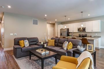 Wyoming apartment for rent - A modern living room with grey couches and yellow pillows.