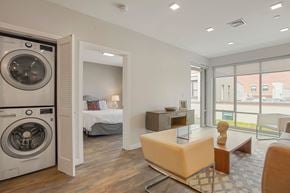 Cambridge apartment for rent - a living room with a washing machine and a bedroom with a bed