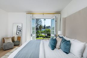 Pacific Palisades apartment for rent - A bedroom with a large bed and a view of the outdoors through the window.