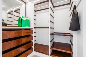Pacific Palisades apartment for rent - A black bag hangs on a hook in a white and wood storage space.