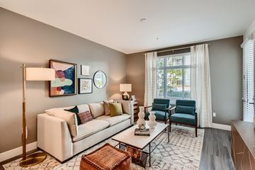 San Diego apartment for rent - A living room with a white couch, a coffee table, and a painting on the wall.