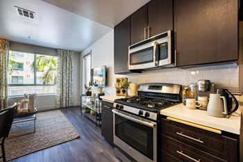 Stainless steel appliances including dishwasher, refrigerator, stovetop oven and mounted microwave