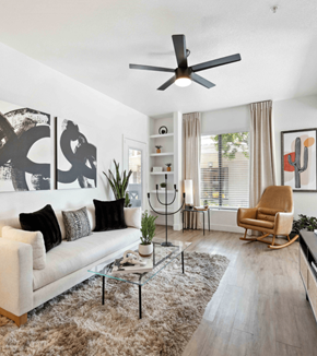 Scottsdale apartment for rent - A living room with a white couch, a glass coffee table, a rocking chair, and a ceiling fan.