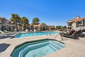 Scottsdale apartment for rent - A large outdoor swimming pool surrounded by lounge chairs and buildings.